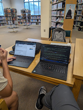 Side-by-side laptops during a coding tutoring session at the library
